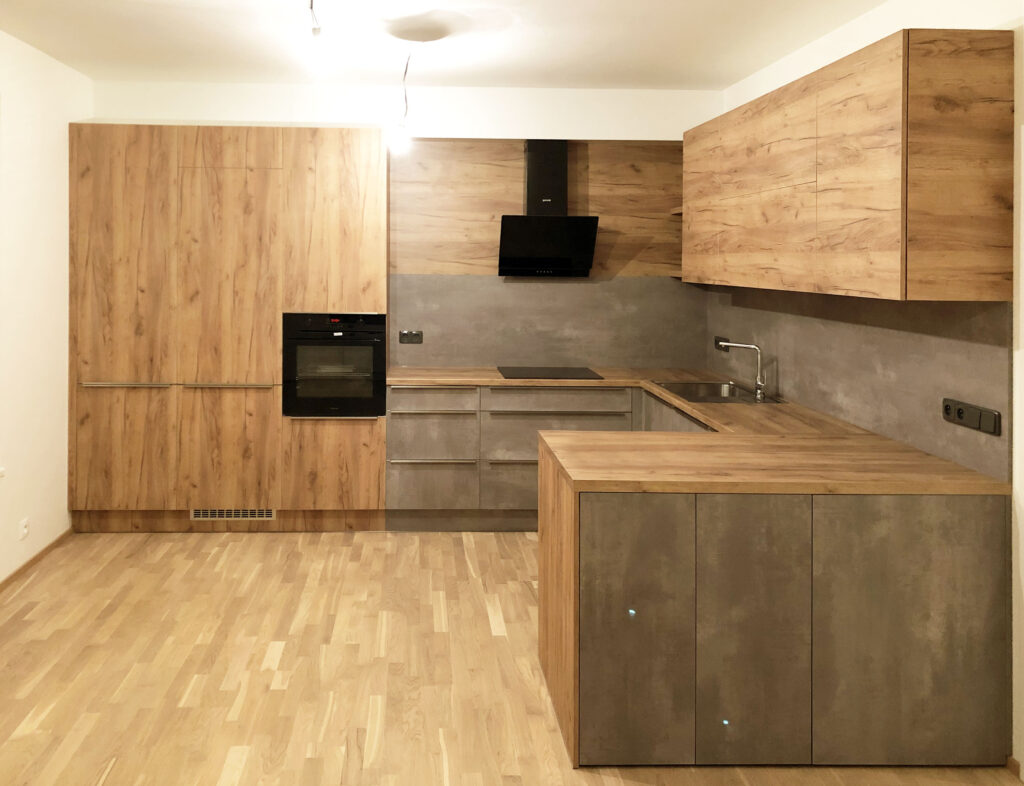 Velká kuchyň do U v kombinaci dub a betonová stěrka.