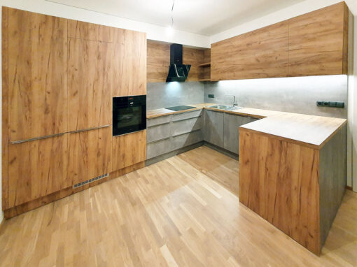 Velká kuchyň do U v kombinaci dub a betonová stěrka.