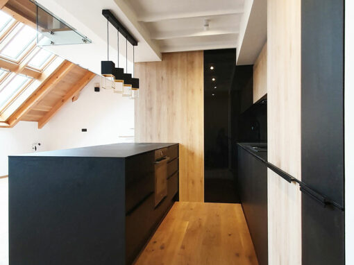 Kuchyň do podkrovního bytu v kombinaci černé matné a přírodní dub.